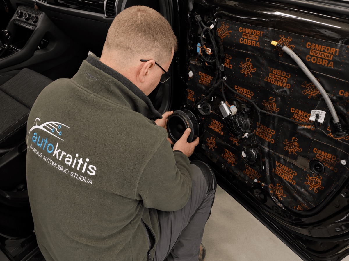 Autokraitis specialistas atlieka durų garso izoliacijos darbus